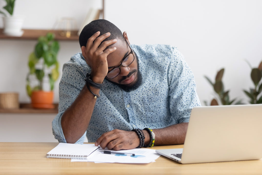 man at desk looking sad